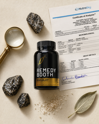 Editorial top-down flat-lay of Shilajit jar with Certificate of Analysis, magnifying glass, mineral stones, sea salt and dried sage